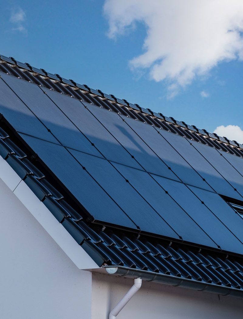 Zonnepanelen voor huiseigenaren - Newly build houses with solar panels attached on the roof against a sunny sky - Allimex Green Power